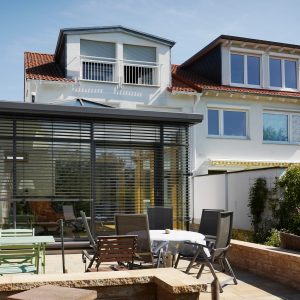 Flat roof Wintergarten with large hipped roof dome and clerestory strip on masonry – emphasis on verticality